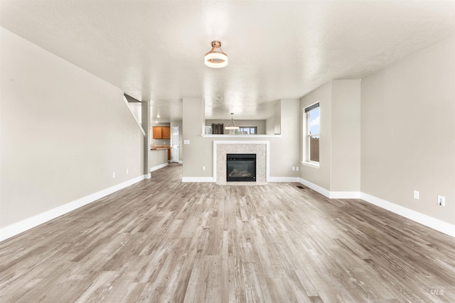 5291 N Midnight Haze Way, Meridian, ID 83646 - unfurnished living room featuring wood finished floors and a fireplace