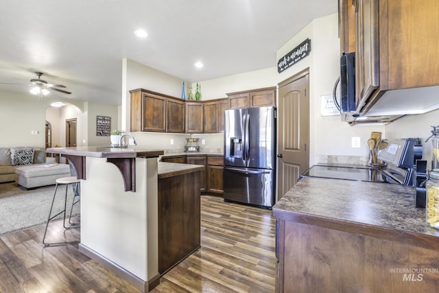 812 Kelli Ln, Filer, ID 83328 - kitchen with open floor plan, a peninsula, dark wood-style floors, stainless steel appliances, and a breakfast bar area