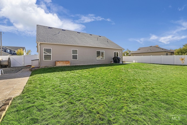 812 Kelli Ln, Filer, ID 83328 - back of property featuring a yard, a fenced backyard, a shingled roof, and a patio area