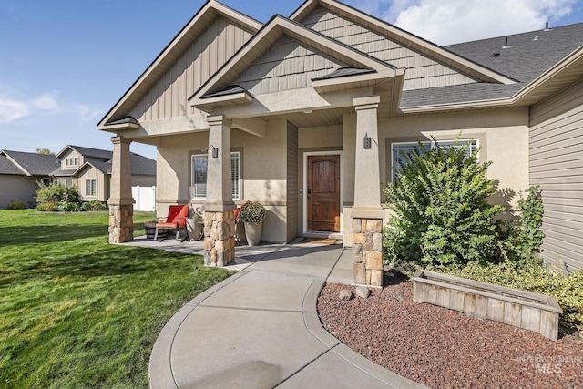 812 Kelli Ln, Filer, ID 83328 - property entrance with roof with shingles, board and batten siding, stucco siding, and a lawn