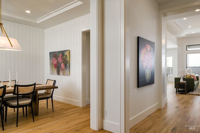 dining space with light hardwood / wood-style flooring and crown molding