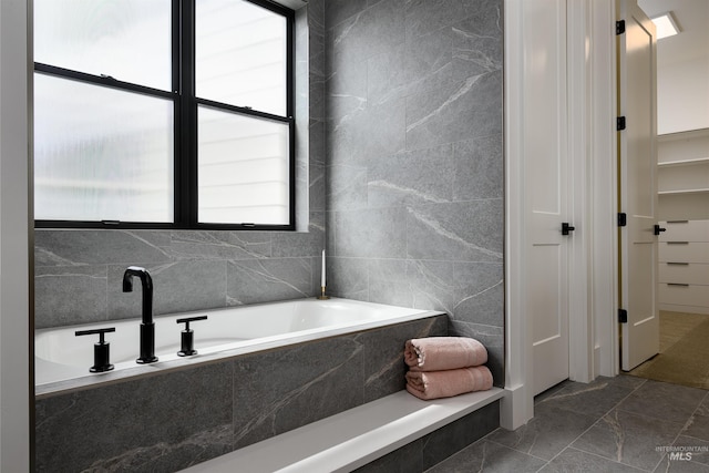 bathroom featuring tile walls, tile flooring, and tiled tub