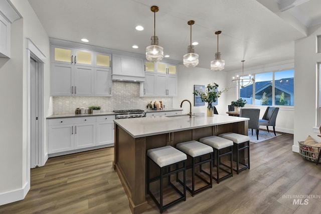 2477 E Galleon Ln, Meridian, ID 83642 - kitchen featuring a sink, dark wood finished floors, baseboards, tasteful backsplash, and a kitchen breakfast bar