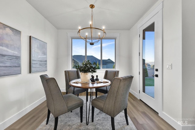 2477 E Galleon Ln, Meridian, ID 83642 - dining area featuring a chandelier, wood finished floors, and baseboards