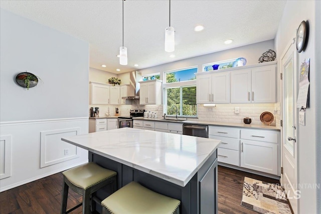 2668 N Morello, Meridian, ID 83646 - kitchen with wall chimney exhaust hood, white cabinets, a center island, a sink, and stainless steel appliances