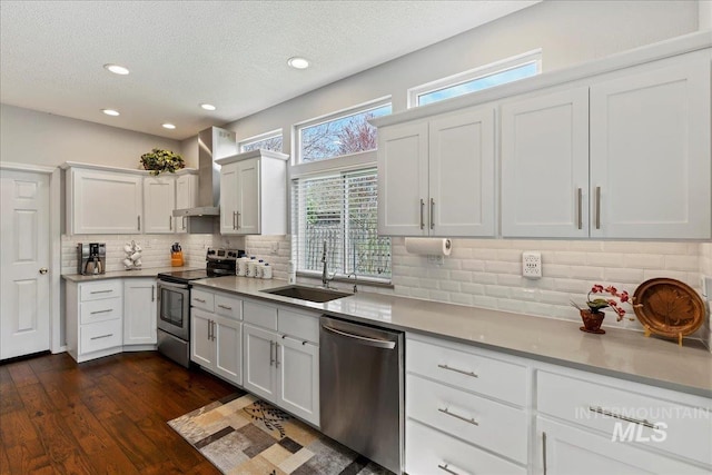 2668 N Morello, Meridian, ID 83646 - kitchen with a sink, wall chimney range hood, dark wood-style floors, stainless steel appliances, and backsplash