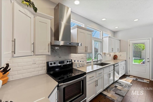 2668 N Morello, Meridian, ID 83646 - kitchen with wall chimney range hood, light countertops, backsplash, appliances with stainless steel finishes, and a sink