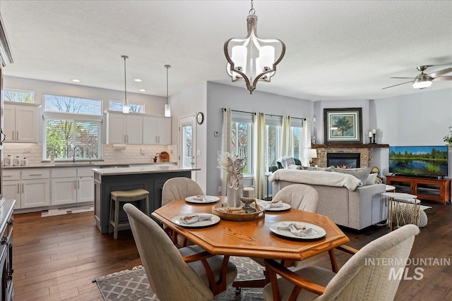 2668 N Morello, Meridian, ID 83646 - dining room featuring a glass covered fireplace, plenty of natural light, dark wood-style flooring, and a textured ceiling