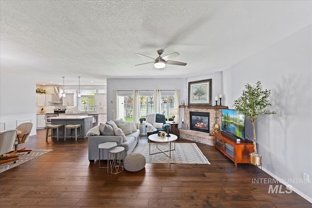 2668 N Morello, Meridian, ID 83646 - living area with dark wood-type flooring, a ceiling fan, a brick fireplace, and a textured ceiling