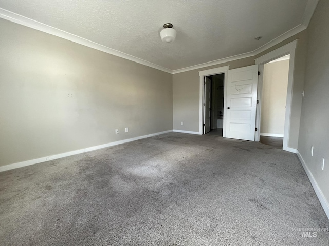 spare room featuring carpet floors, baseboards, and a textured ceiling