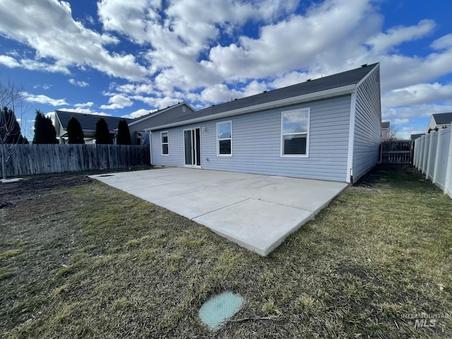 rear view of property featuring a yard, a fenced backyard, and a patio