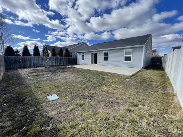 back of property with a fenced backyard, a patio, and a lawn