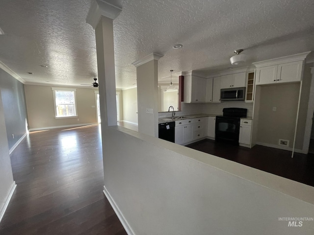 kitchen with dark wood-style flooring, white cabinetry, a sink, and black appliances