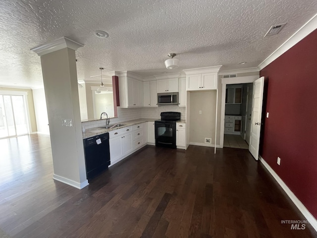 kitchen with dark wood finished floors, a sink, black appliances, white cabinetry, and backsplash