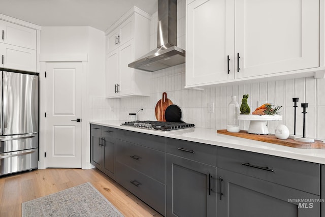 205 S Sunniva Ave, Kuna, ID 83634 - kitchen with appliances with stainless steel finishes, wall chimney exhaust hood, gray cabinetry, and white cabinets