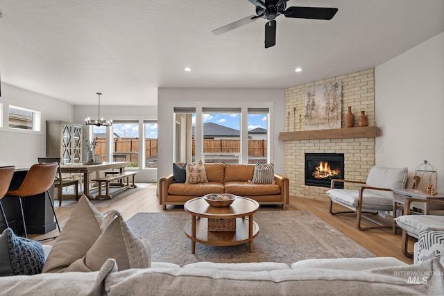 205 S Sunniva Ave, Kuna, ID 83634 - living room with wood finished floors, a chandelier, a ceiling fan, a fireplace, and recessed lighting