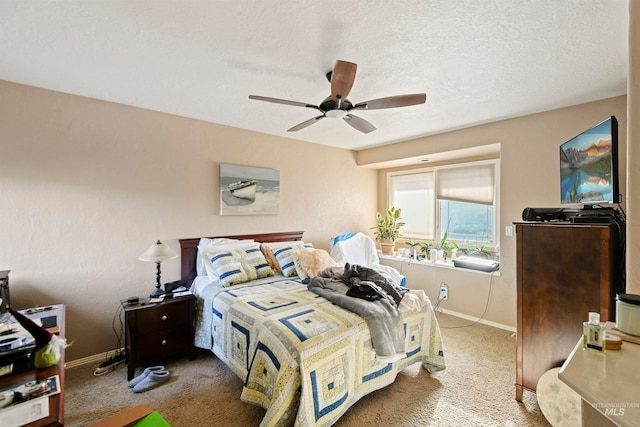 bedroom featuring ceiling fan, carpet flooring, and a textured ceiling