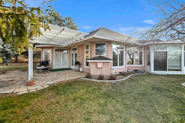 back of property with a patio, a lawn, and a pergola