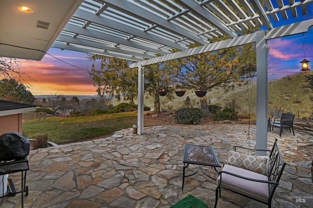 patio terrace at dusk featuring area for grilling and a pergola