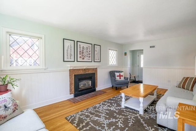 517 E C St, Moscow, ID 83843 - living area with wood finished floors, wainscoting, a tiled fireplace, and baseboards
