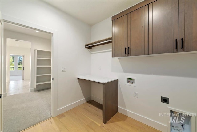 clothes washing area with washer hookup, light hardwood / wood-style flooring, cabinets, and hookup for an electric dryer