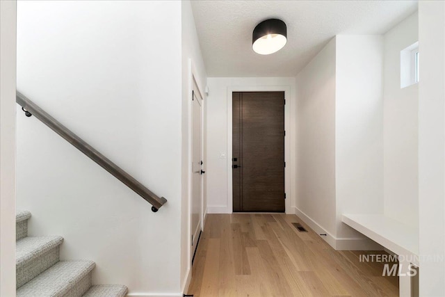 interior space featuring a textured ceiling and light hardwood / wood-style flooring