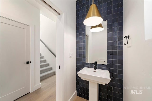 bathroom featuring hardwood / wood-style flooring and tile walls