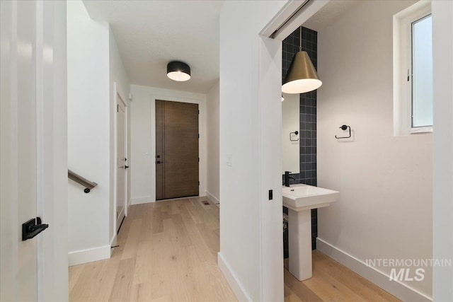 corridor with light hardwood / wood-style floors