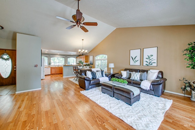 living room featuring ceiling fan with notable chandelier, lofted ceiling, and light hardwood / wood-style floors