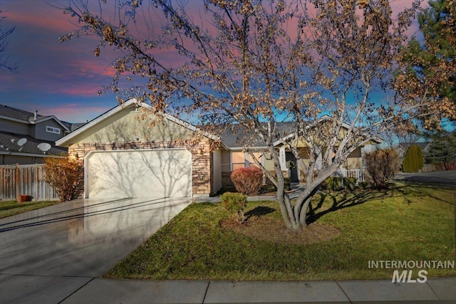 single story home featuring a lawn and a garage