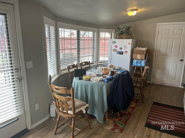 dining area with baseboards and wood finished floors