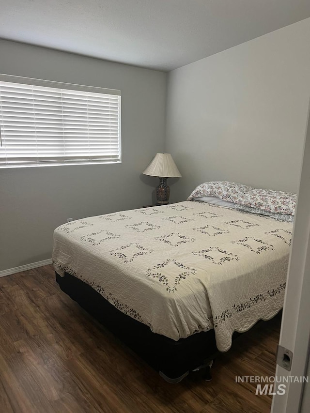 bedroom with baseboards and wood finished floors