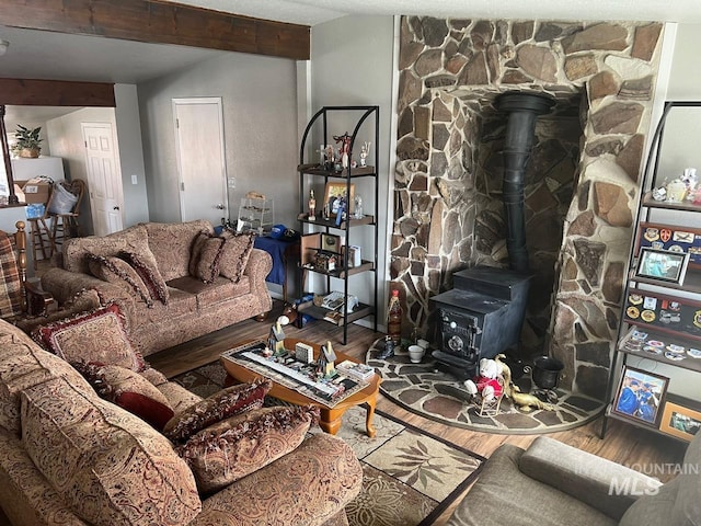 living room with a wood stove and wood finished floors