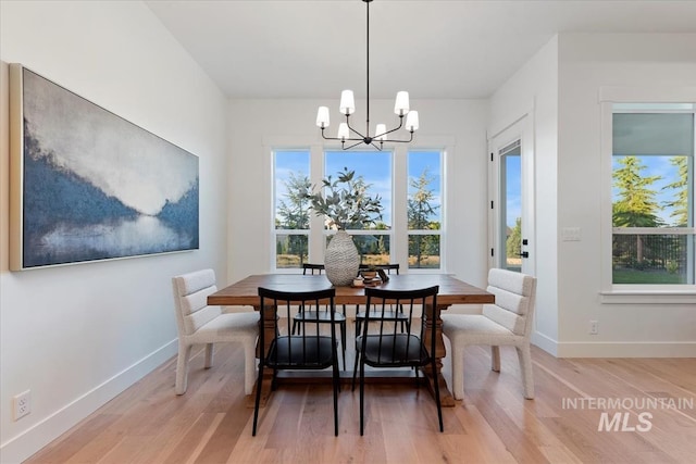 dining area featuring baseboards, a chandelier, and light wood-style flooring