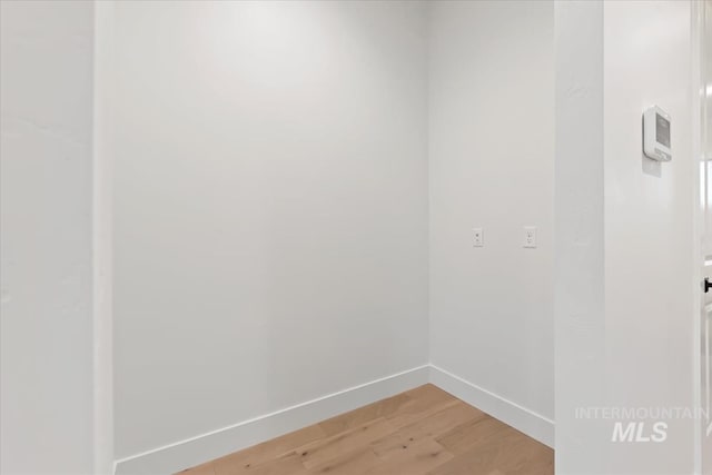 empty room featuring baseboards and light wood-style floors