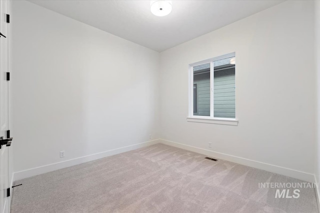 spare room with visible vents, baseboards, and light colored carpet