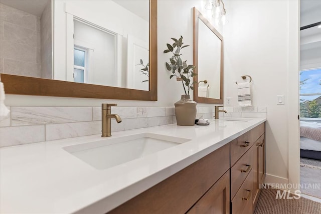 ensuite bathroom with ensuite bath, a sink, and double vanity