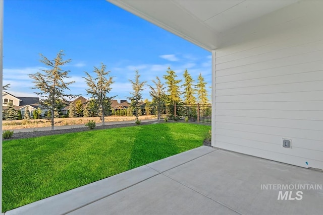 view of yard featuring fence, a residential view, and a patio