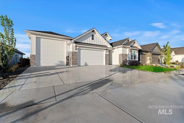 view of front facade featuring driveway, stone siding, fence, a garage, and board and batten siding