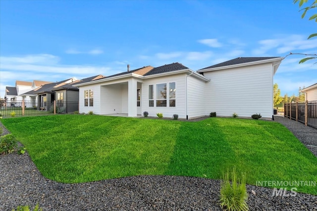 back of property with a lawn and a fenced backyard