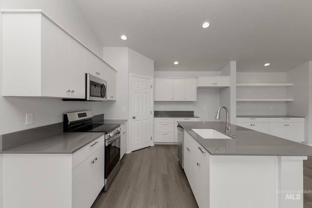 5754 W Stavros St, Meridian, ID 83646 - kitchen with appliances with stainless steel finishes, a sink, open shelves, wood finished floors, and white cabinets