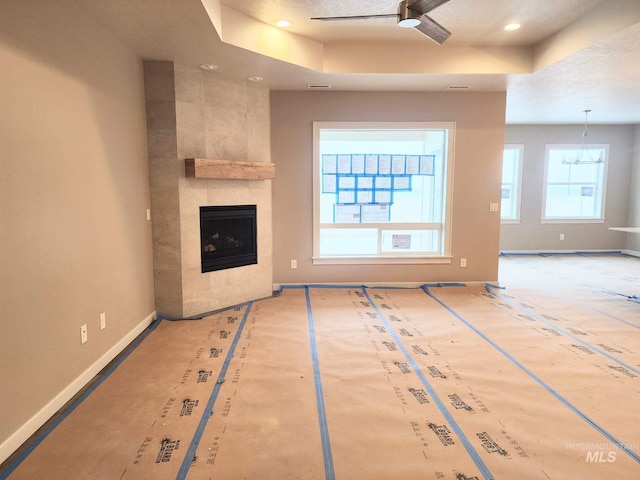 unfurnished living room featuring a raised ceiling and a fireplace