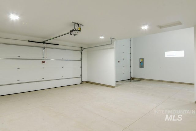 garage featuring baseboards, electric panel, and a garage door opener