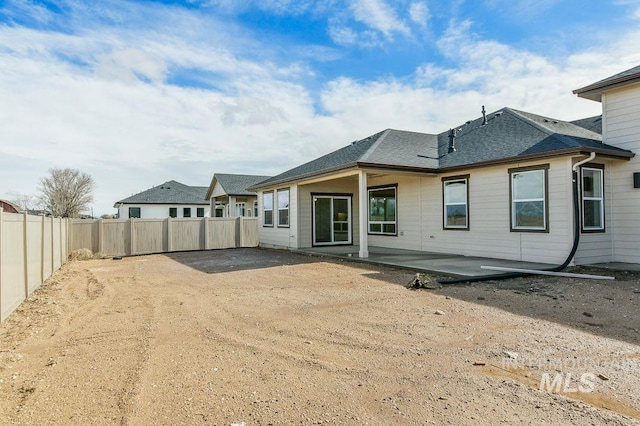 back of property featuring a patio area, a fenced backyard, and a shingled roof