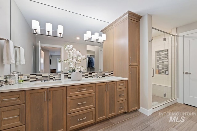bathroom with a sink, double vanity, decorative backsplash, and a stall shower