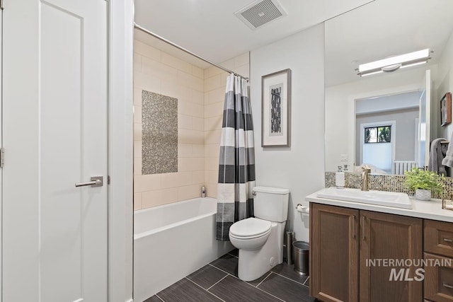 bathroom featuring tasteful backsplash, toilet, visible vents, vanity, and shower / bath combo