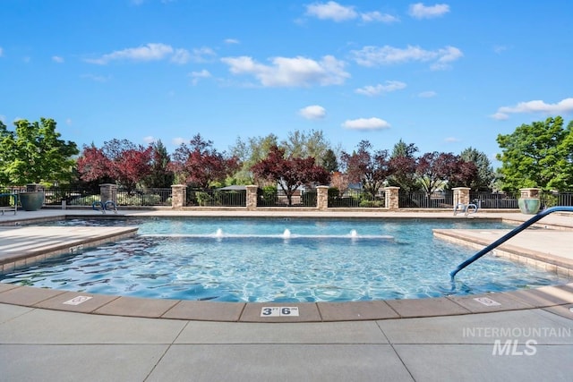 pool featuring fence and a patio area