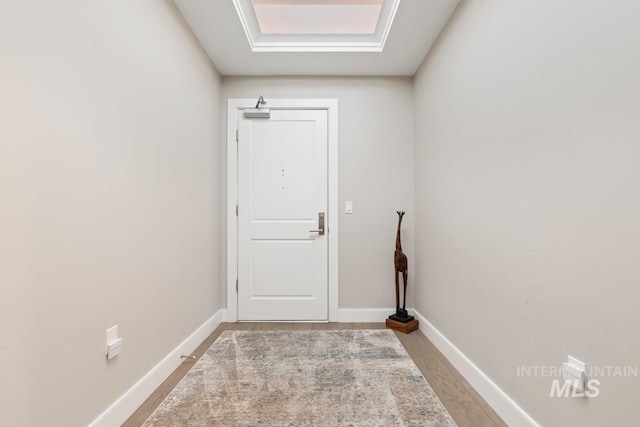 doorway to outside featuring wood finished floors and baseboards