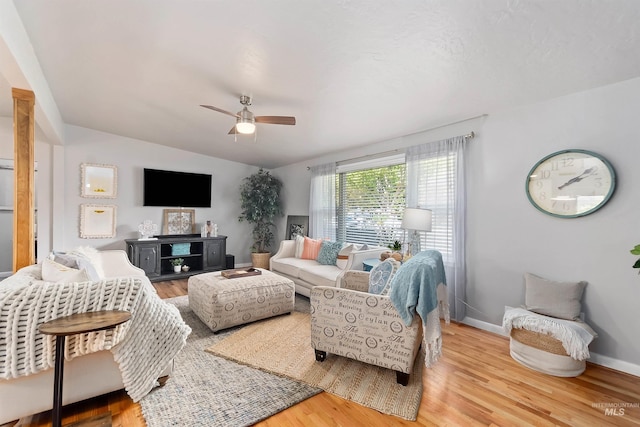 living room featuring ceiling fan, hardwood / wood-style flooring, and vaulted ceiling