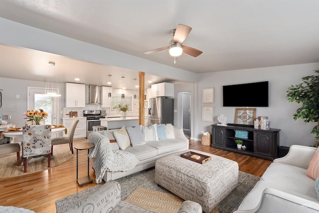 living room featuring light wood-type flooring and ceiling fan